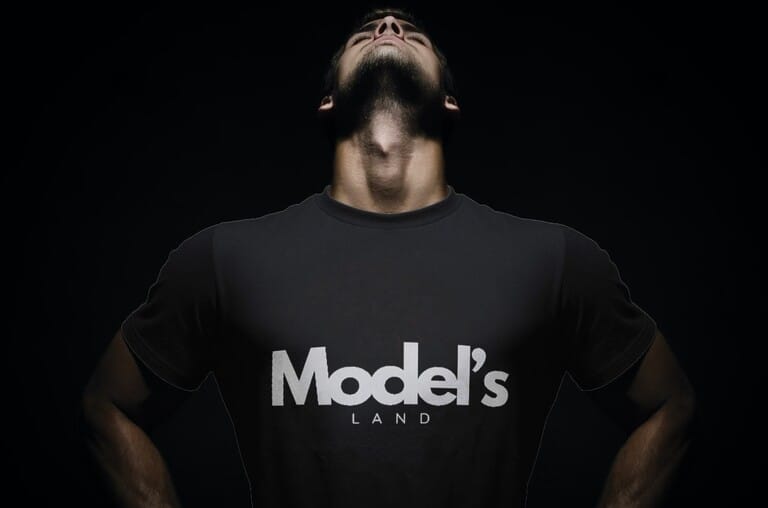 Man wearing black shirt titled "Model's Land